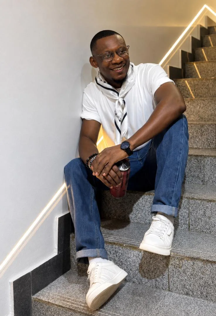 j BOLD standing on a staircase in a full-length portrait